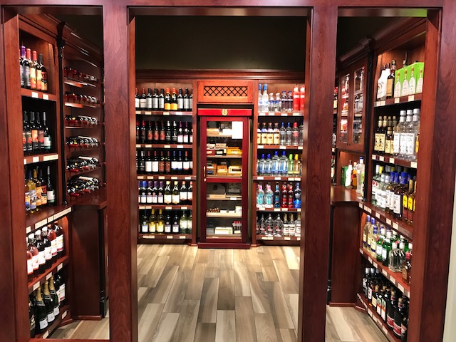 Wooden door frame showing bottles of alcohol and a large cigar humidor.