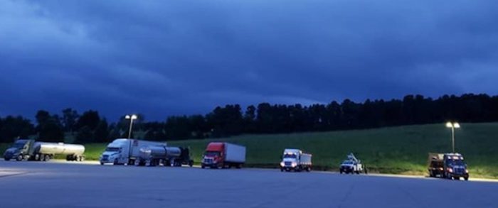 Semi trucks and trailers parked under a blue night sky