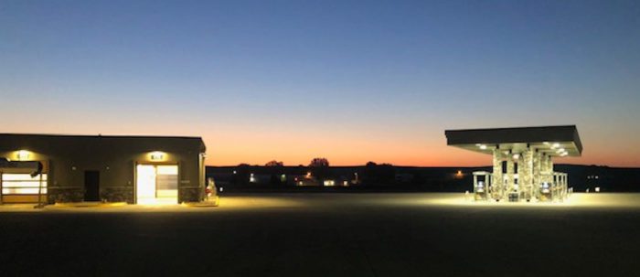 Dusk, orange sunset over car wash and gas station pumps at waspy's truck stop